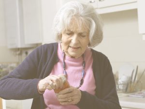 En la imagen, vemos a una señora mayor en su cocina, tratando de abrir un tarro de comida. Por su gesto percibimos que le cuesta mucho esfuerzo. El dolor y la rigidez que provoca la rizartrosis puede impedir a la persona mayor realizar el movimiento de pinza, necesario en muchas tareas cotidianas, limitando así su autonomía. Algunas pautas pueden ayudarnos a prevenirla y ralentizar su progresión.