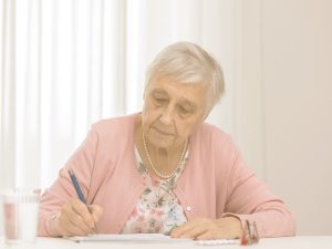 El deterioro cognitivo que conlleva la edad puede afectar al lenguaje. Ciertos ejercicios pueden ayudar a mantener la fluidez verbal. En la imagen, una mujer mayor escribe en un cuaderno.