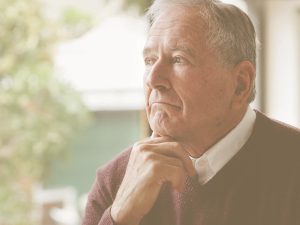 Ejercicios para entrenar la memoria en personas mayores. En la imagen, vemos a un hombre mayor con la mirada ligeramente perdida, pensando.